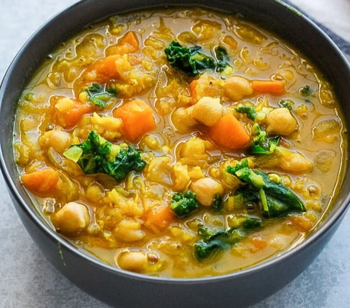 Bowl of immunity soup filled with fresh vegetables and herbs for health benefits
