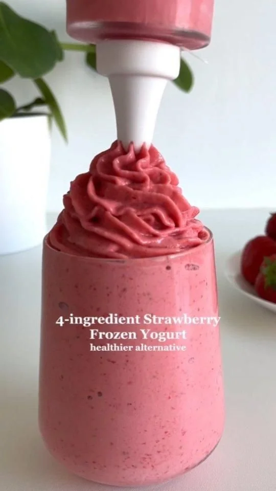 Bowl of creamy 4-ingredient strawberry frozen yogurt garnished with fresh strawberries.