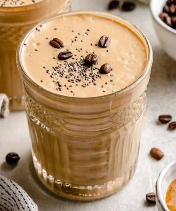Delicious creamy coffee smoothie in a glass with toppings